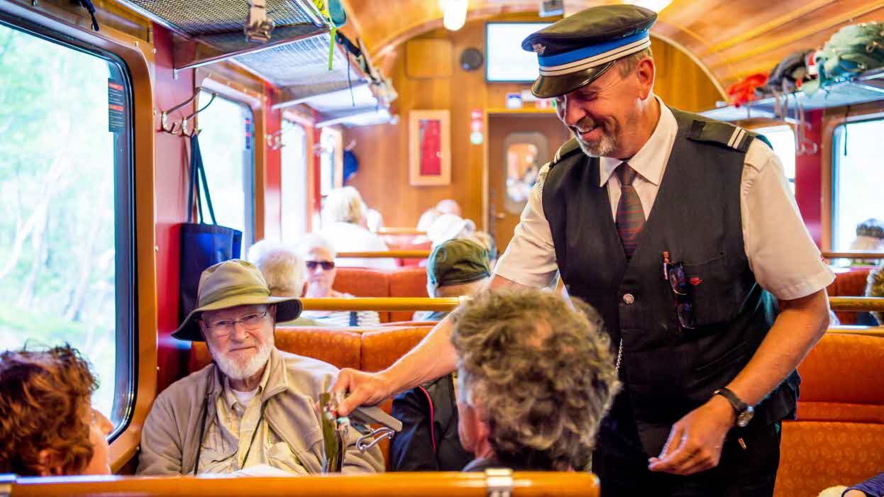 A conductor checking tickets on board the Flåm Railway