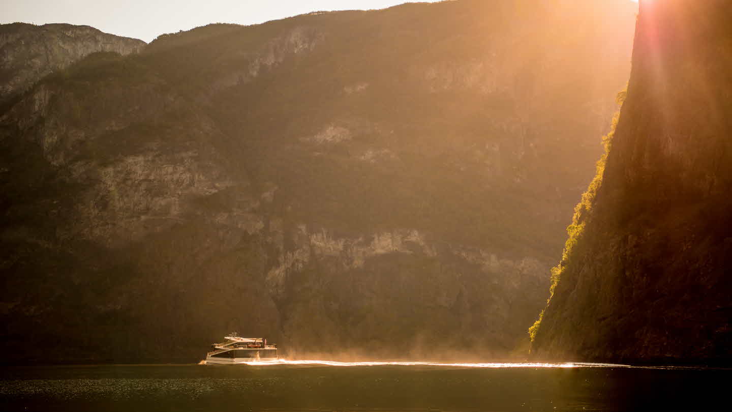 Solnedgong bryter fjellside og lyser opp Future of The Fjords i Nærøyfjorden