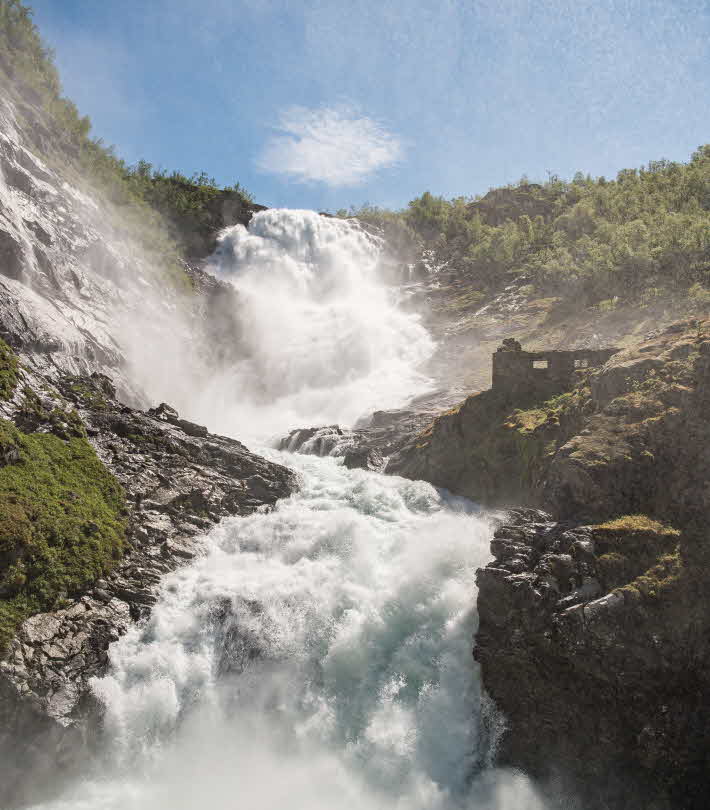 Un gran torrente de agua fluyendo por Kjosfossen, junto al ferrocarril de Flåm