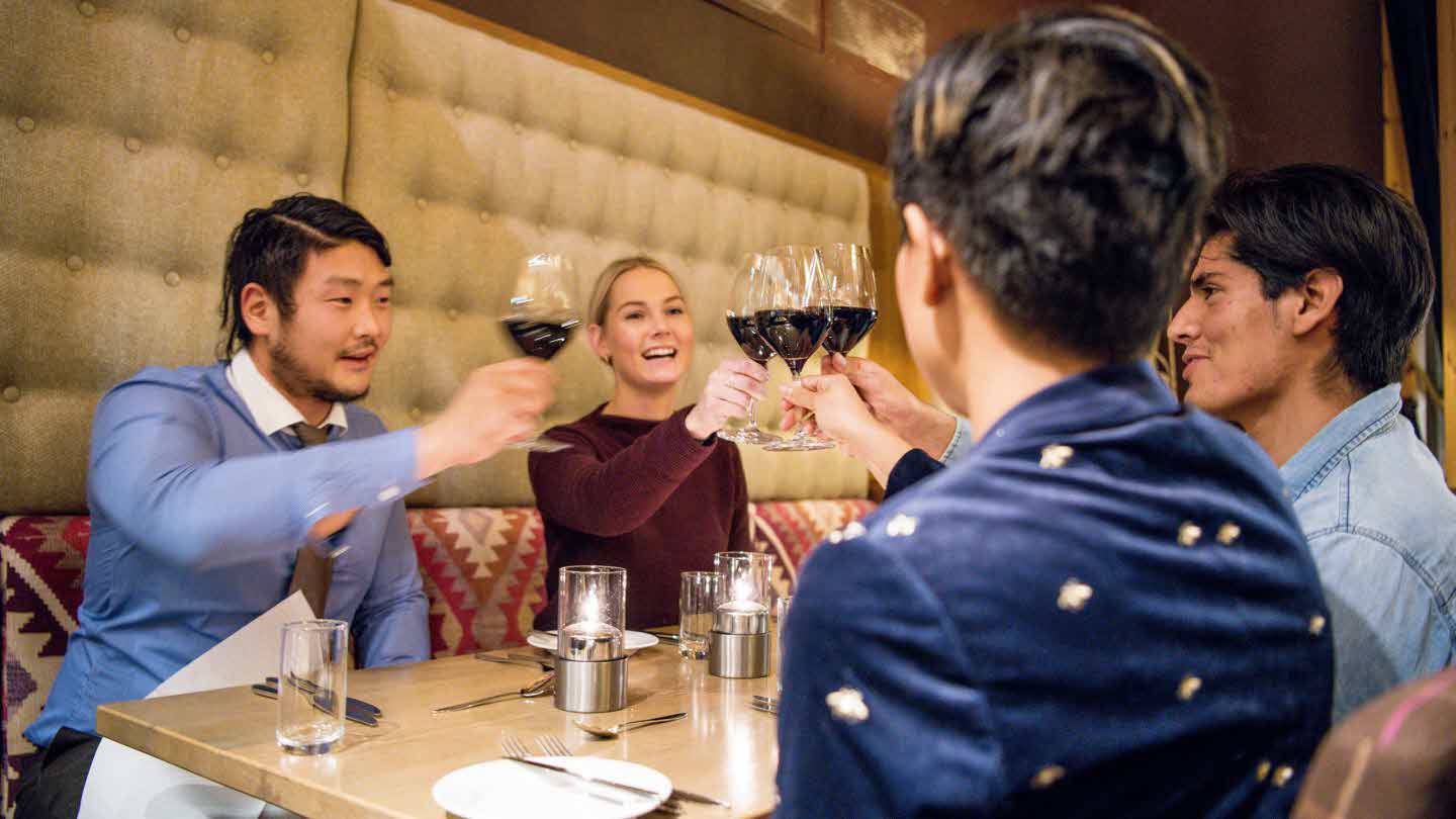 Fire personar skåler med rødvinsglas i restaurant Arven