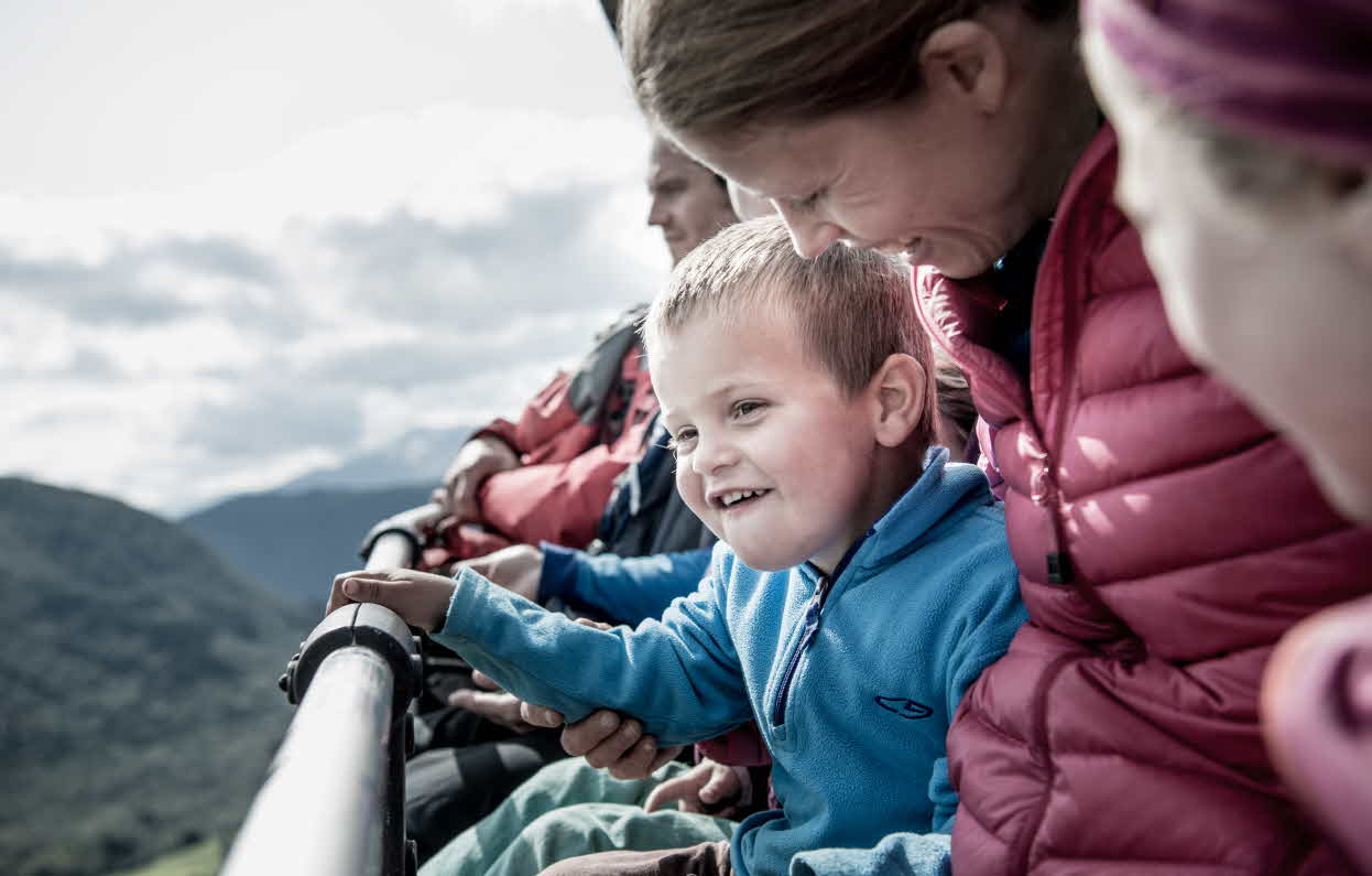 A family sitting in the chairlift on their way to the mountain in Myrkdalen