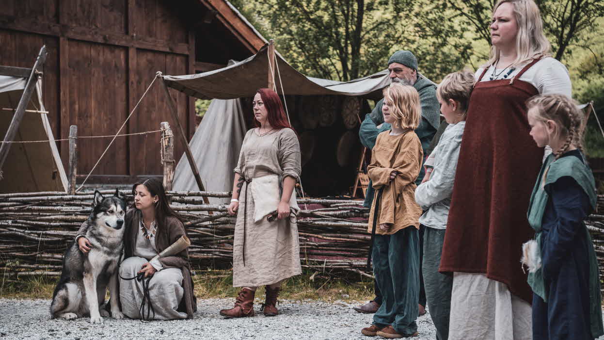 A group of Vikings with children and a dog in the Viking Village in Gudvangen