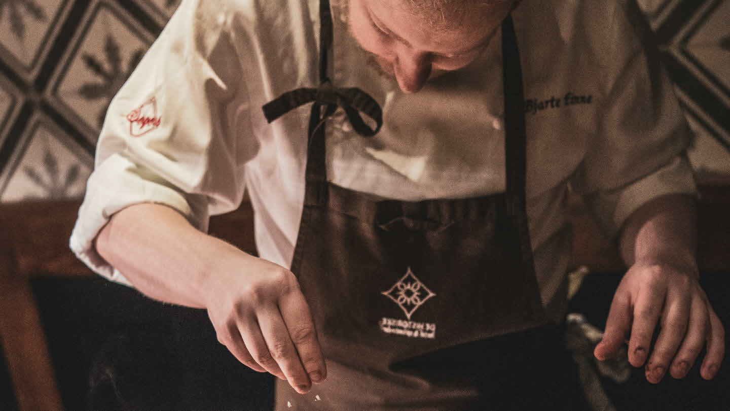 Ein person går mot Fretheim Hotel som er pynta med julebelysning og juletre